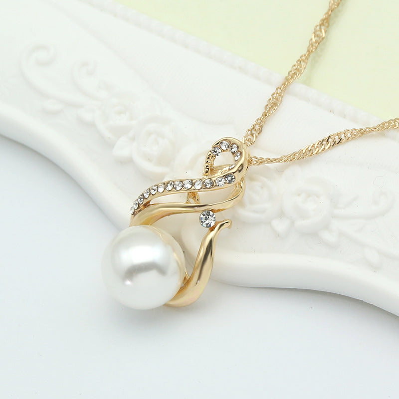 Pearl pendant necklace with gold-tone curved design and crystal accents.