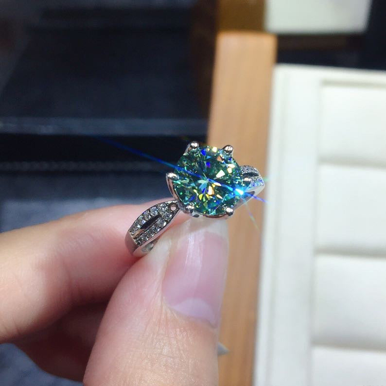 Adjustable 925 silver ring with a blue-green moissanite center stone and pavé-set accents