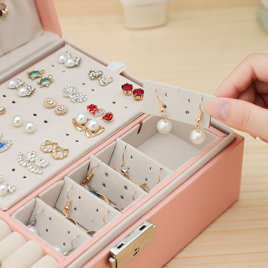Double-layer leather jewelry storage box by Edenista in pink, with multiple compartments holding many earrings.