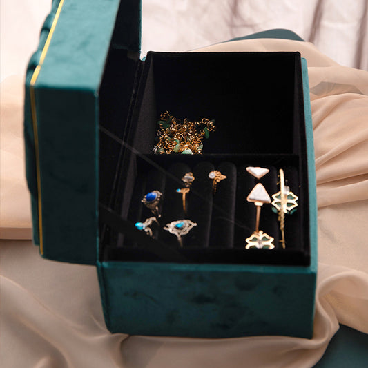 Jewelry storage box in green velvet with black interior and multiple compartments
