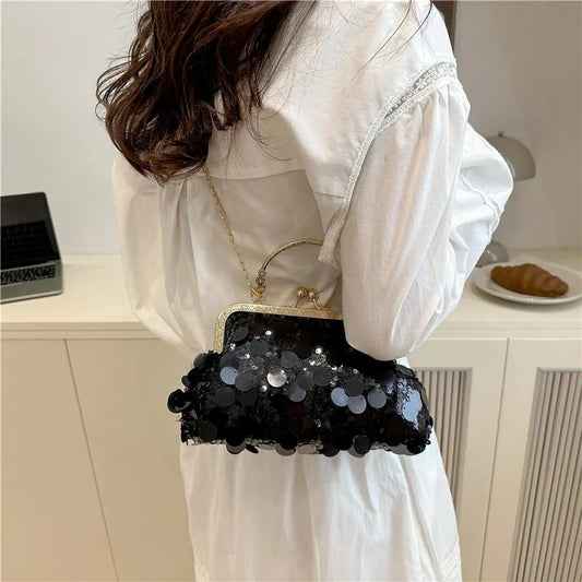 Elegant sequined shoulder bag in black with a gold frame and chain strap