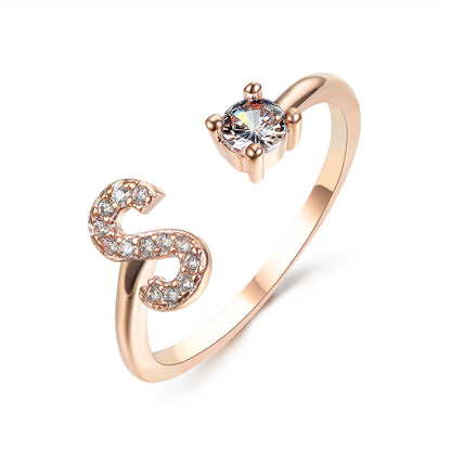Rose gold S-shaped initial letter ring with pavé crystals and a solitaire center stone