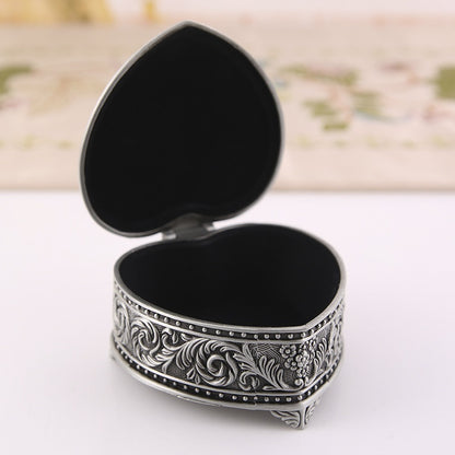 Jewelry storage box, heart-shaped, with silver-tone floral engraving and black interior.