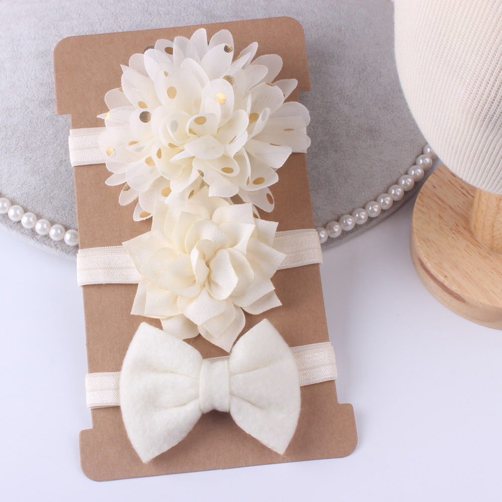 Three-piece floral baby stretch hairband set with ivory flower clusters and a white bow on cardboard backing