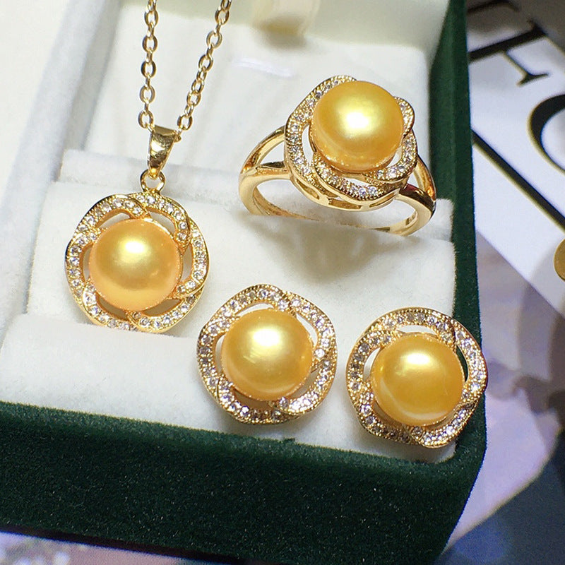 Gold-tone freshwater pearl jewelry set with crystal accents; includes pendant necklace, ring, and two earrings.