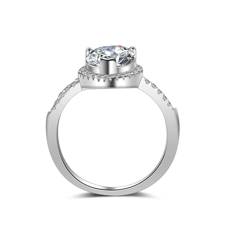 Diamond ring by cj featuring a solitaire center stone and pavé-band in silver-toned metal.