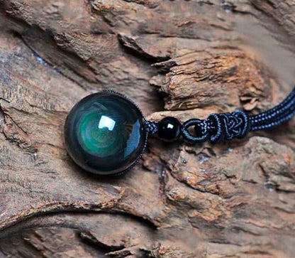 Obsidian rainbow eye pendant on a dark blue braided polyester rope chain necklace