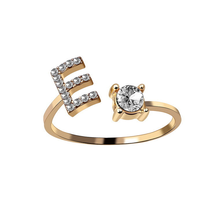 Initial letter ring by edenista in gold with diamond-studded E and solitaire setting, adjustable