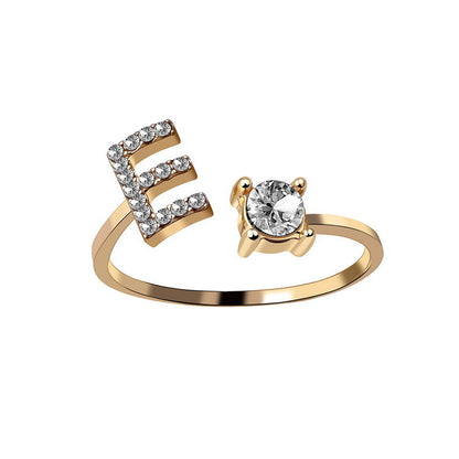 Initial letter ring by edenista in gold with diamond-studded E and solitaire setting, adjustable