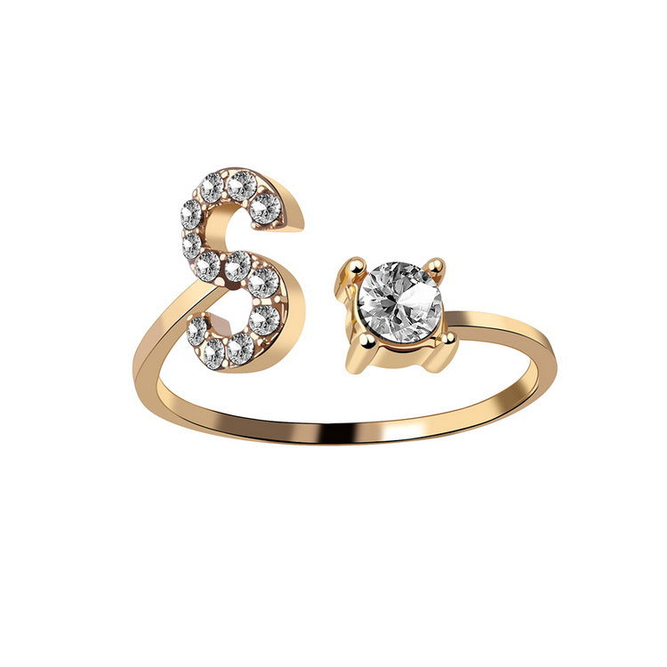 Gold-tone adjustable ring featuring a diamond-accent curved end and a solitaire stone on the opposite end.