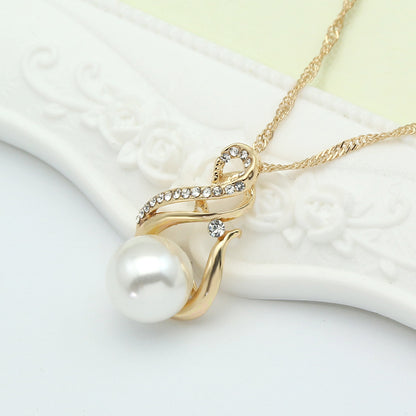 Pearl pendant necklace with gold-tone curved design and crystal accents.