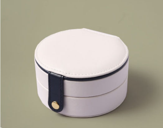 Portable jewelry box, white round case with a dark blue strap and gold button.