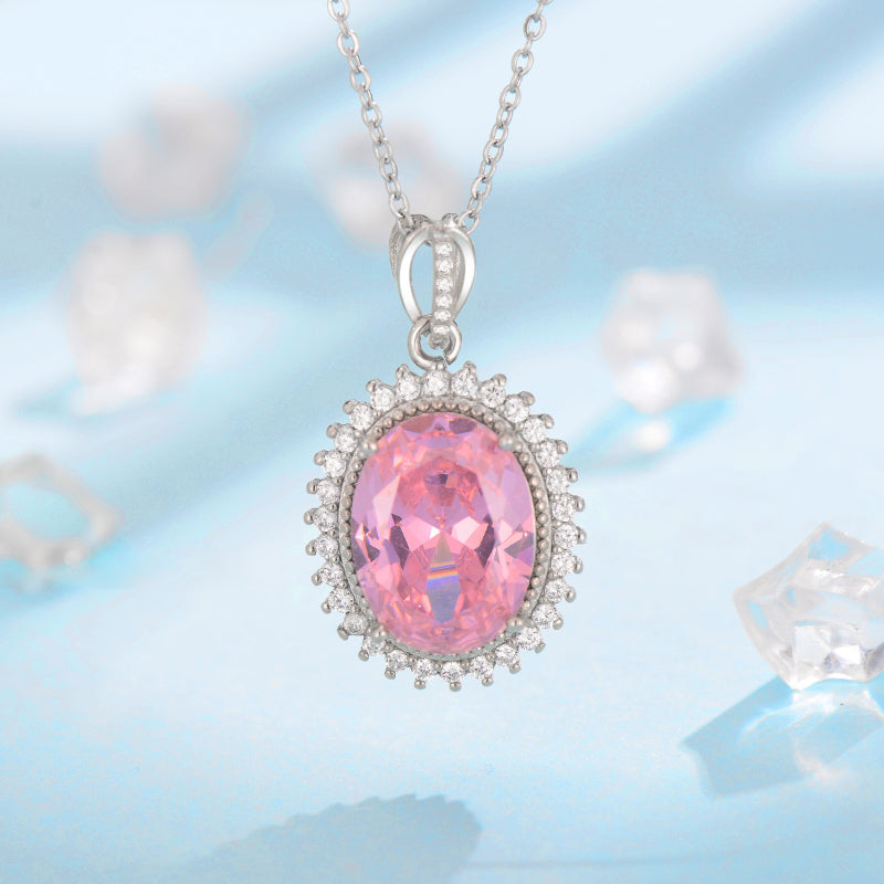 Pendant necklace with an oval pink gemstone surrounded by a diamond halo on a silver chain