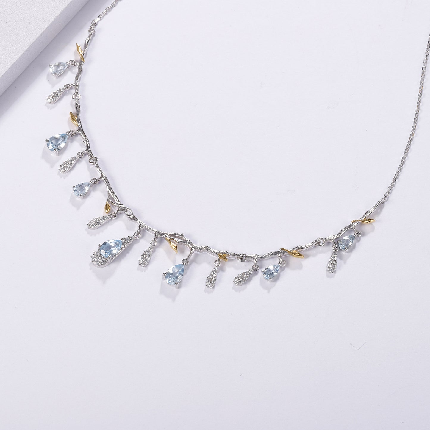 S925 silver natural topaz necklace with blue teardrop gems, crystal charms, and gold-tone leaf accents on a branch chain