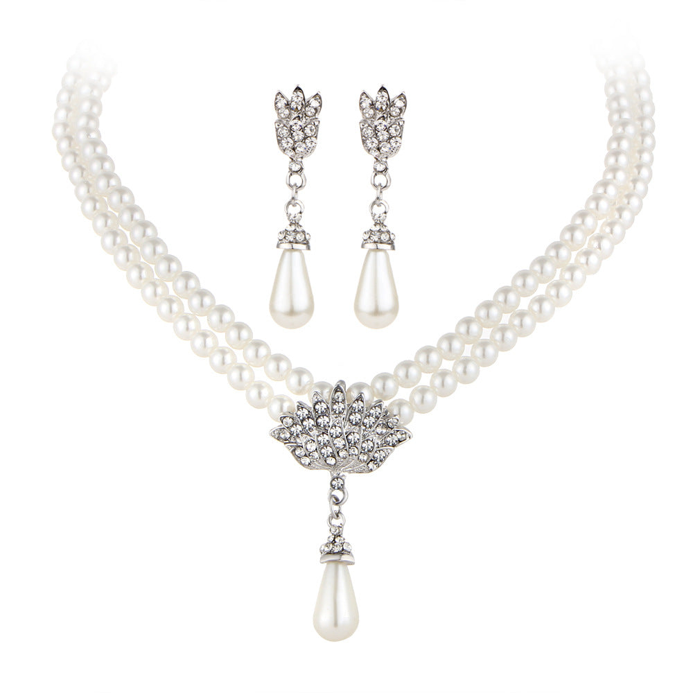 Clavicle necklace set with double-strand pearls, crystal centerpiece, and matching pearl drop earrings