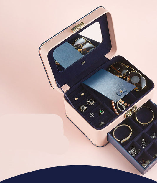 Storage box by edenista; blush pink exterior with navy velvet interior and multiple jewelry compartments.