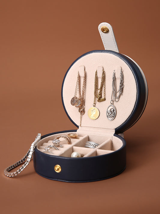 Portable jewelry box edenista, navy blue exterior with beige interior, round travel case showcasing necklaces and rings.