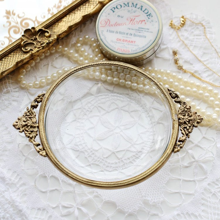 Handmade round brass-edged jewelry box with ornate side handles and glass top.