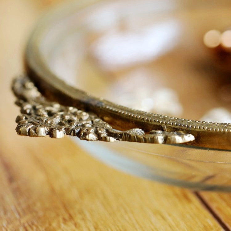 Handmade brass-edged jewelry box with ornate floral trim on a wooden surface