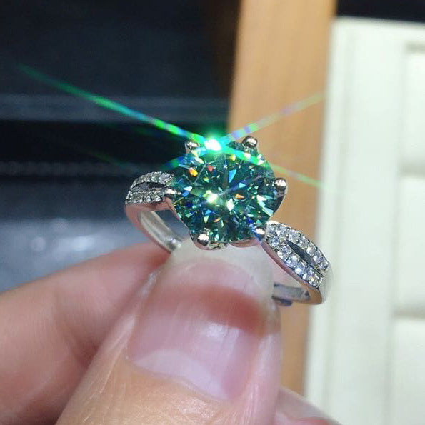 Ring with blue-green moissanite centerpiece on an adjustable 925 sterling silver band for women.