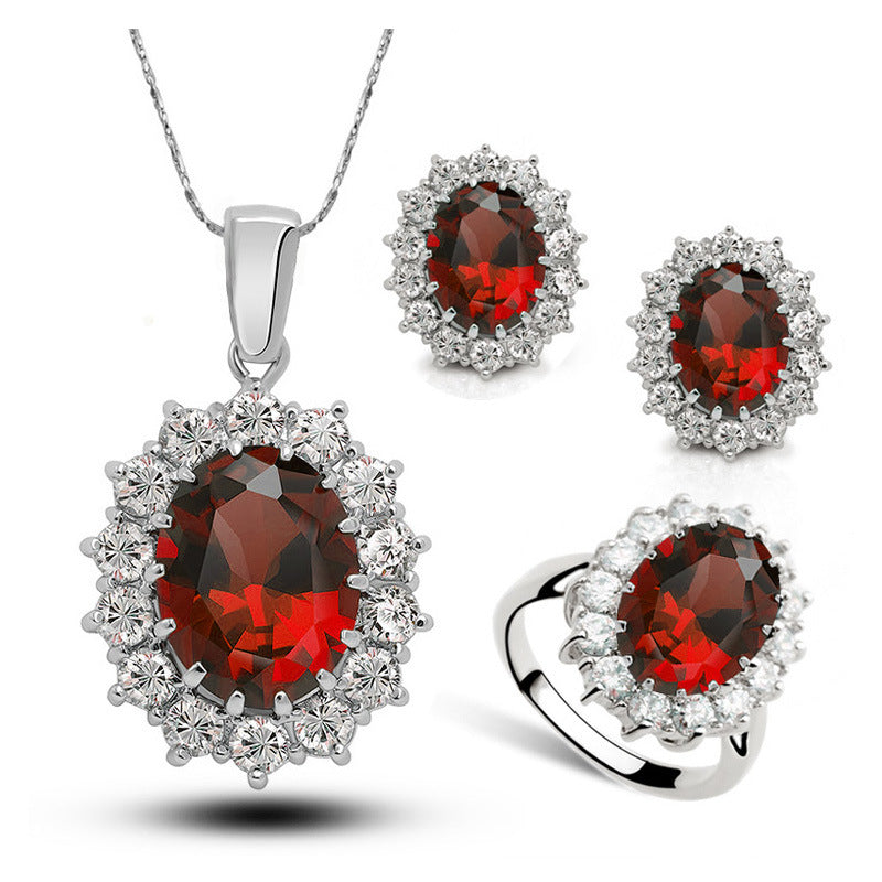Crystal bridal jewelry set: red centerpiece pendant necklace with halo of crystal stones, matching earrings and ring