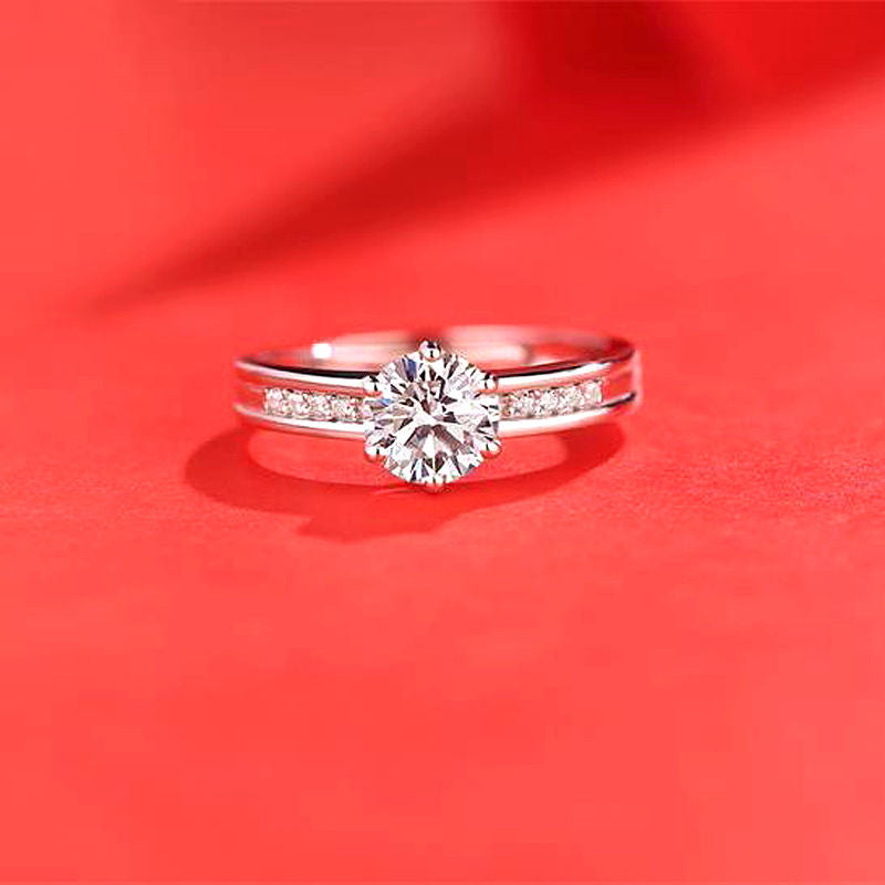 Women's moissanite ring with a large center stone and pavé band in silver-tone metal.
