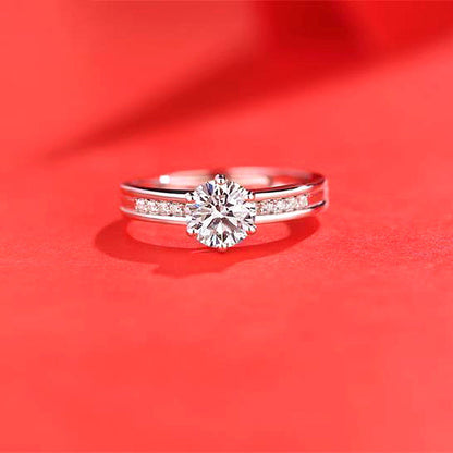 Women's moissanite ring with a large center stone and pavé band in silver-tone metal.