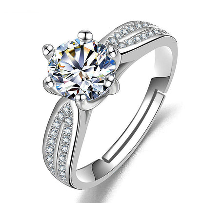 Women's ring with a large round moissanite centerpiece and pavé-set shoulders on a silver band