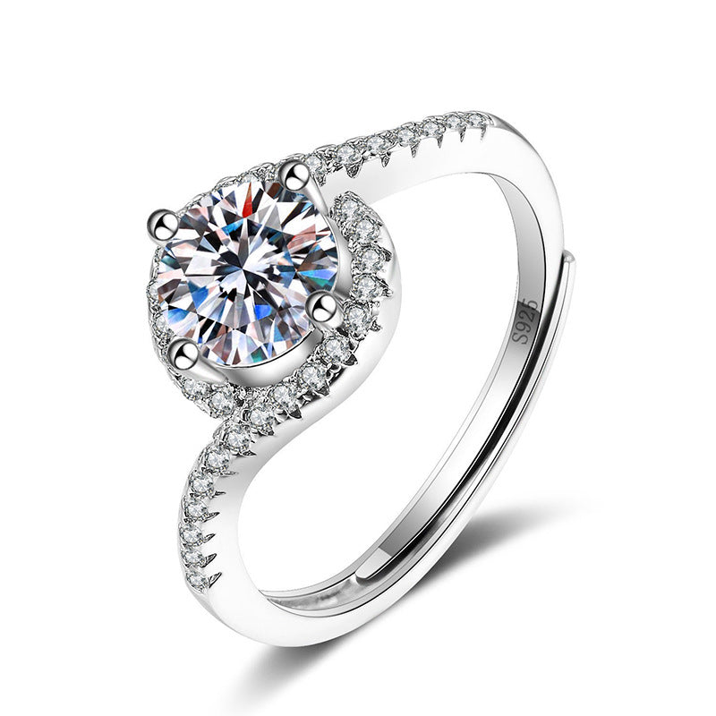 Female ring with large imitation moissan diamond, halo and pavé stones, silver-toned split-shank band.