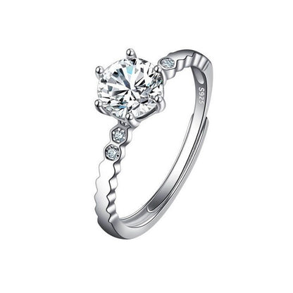 Female ring with large round imitation moissan diamond, silver-tone band with small accent stones