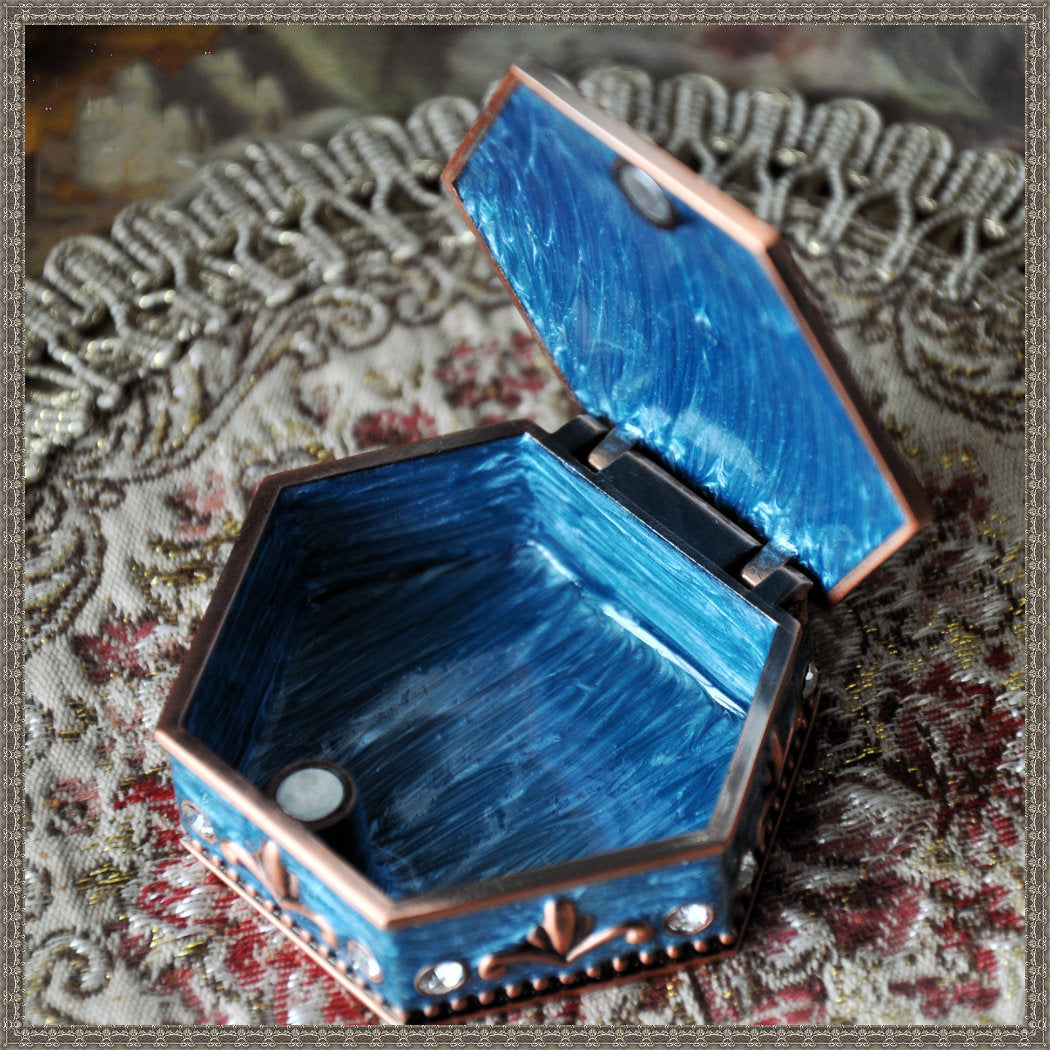 Vintage princess jewelry box by Edenista, hexagonal copper-tone frame with blue marbled interior, lid open.