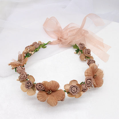 Artificial flower wreath hair accessory for bridal wear in blush pink and peach with a satin ribbon bow