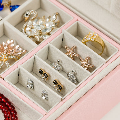 Jewelry box by edenista in pink with beige divided compartments and assorted jewelry.