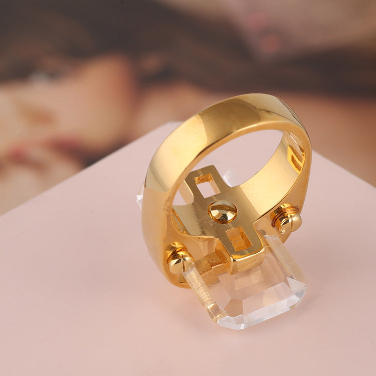 Rectangular natural stone ring by cj in gold-tone with clear crystal centerpiece.