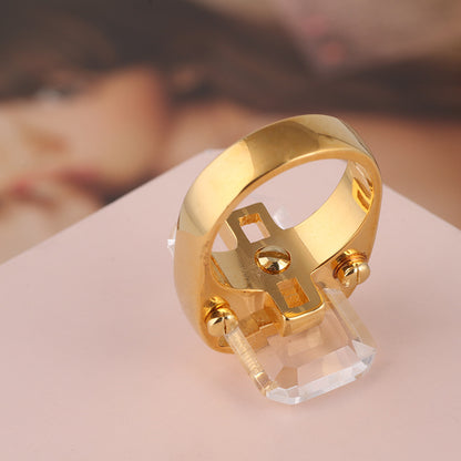 Rectangular natural stone ring by cj in gold-tone with clear crystal centerpiece.
