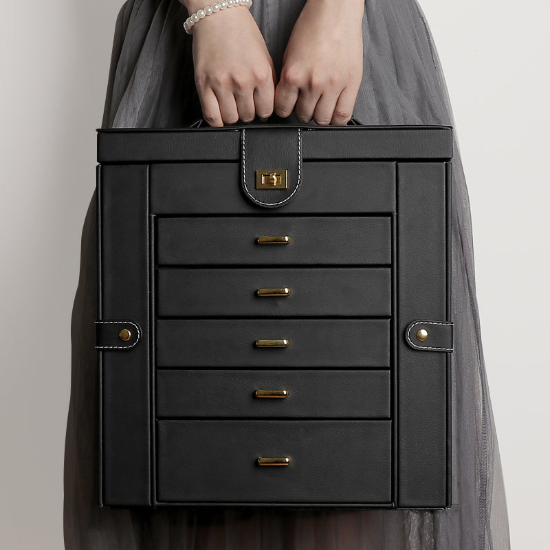Multifunctional jewelry box by edenista in black leather with gold hardware and stacked drawers.