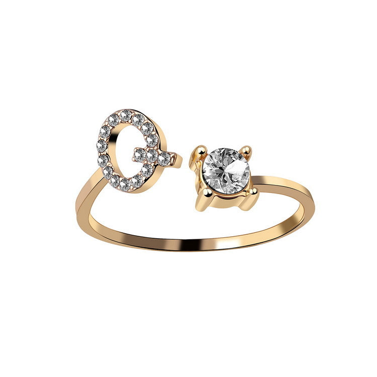 Adjustable ring in gold tone featuring a solitaire stone and a crystal-encrusted open-circle end