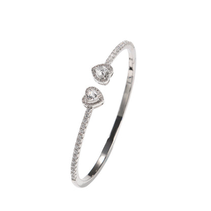 CJ heart-shaped diamond bracelet with pavé diamonds on a silver-toned band