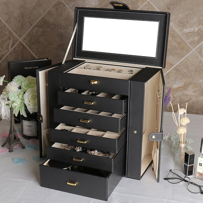 Multifunctional jewelry box by edenista, black leather with gold hardware, open to reveal drawers and a top mirror.