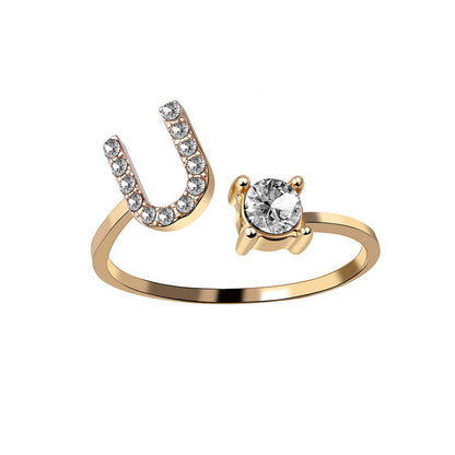 Gold-tone adjustable initial ring with U-shaped diamond-studded end and a solitaire diamond for women