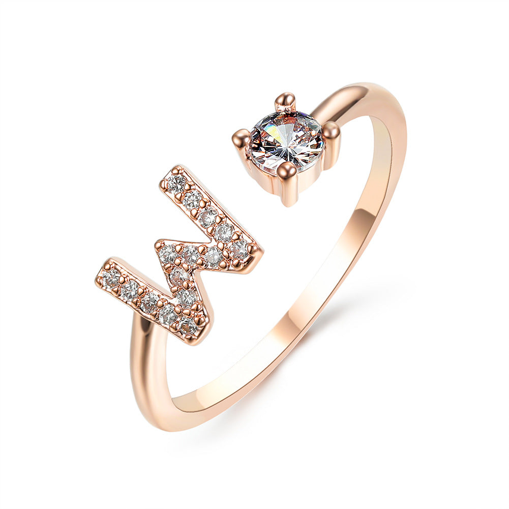 Initial N letter ring by edenista in rose gold with crystal accents and solitaire center stone