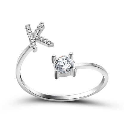Ring, adjustable silver band with diamond-studded X-shaped end and a solitaire diamond setting.