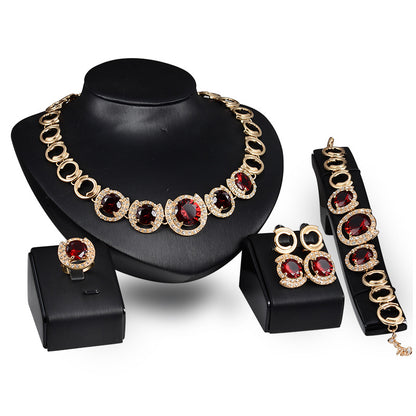 Gold-tone wedding jewelry set, 4-piece with red zircon crystals: necklace, earrings, ring, bracelet