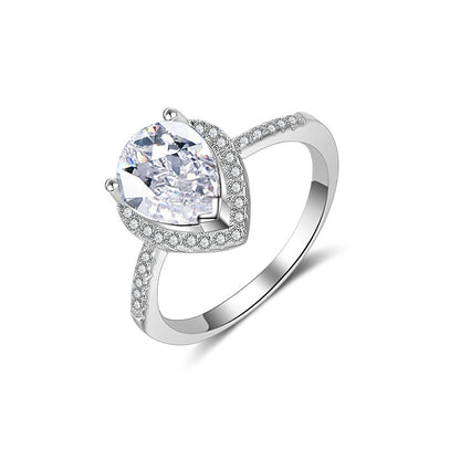Diamond ring with pear-cut center stone, pave halo and band in silver.