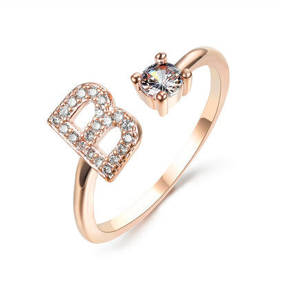 Initial-letter ring in rose gold by edenista with pave diamonds and a solitaire stone