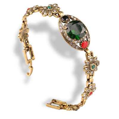Vintage ethnic style bracelet gold-tone with floral links, a large green central gemstone and pavé accents CJ