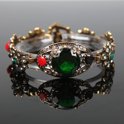 Vintage ethnic style bracelet in antique gold-tone with emerald center stone and crystal accents