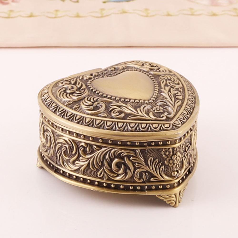 Heart-shaped jewelry storage box with antique gold finish and embossed floral scrollwork.