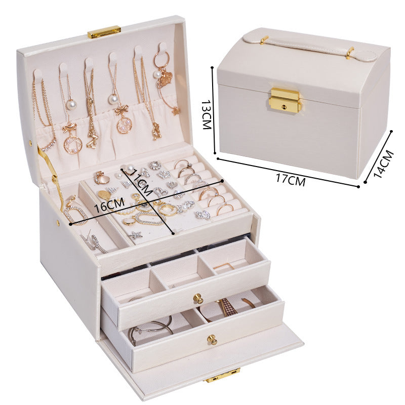 Three-layer cream jewelry storage box with necklace hooks, drawers, and gold hardware.