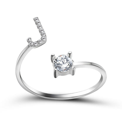Adjustable silver ring with curved pavé-diamond row and a prong-set solitaire diamond.